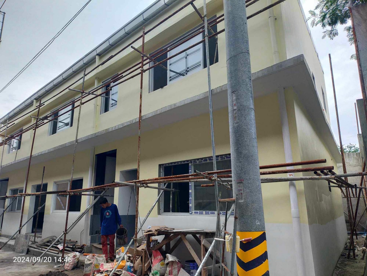 Two-storey staff quarters building with scaffolding in Valenzuela City.